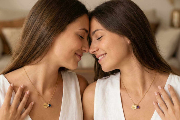 Personalized Jewelry for Your Sister: Two women smiling while wearing matching necklaces.