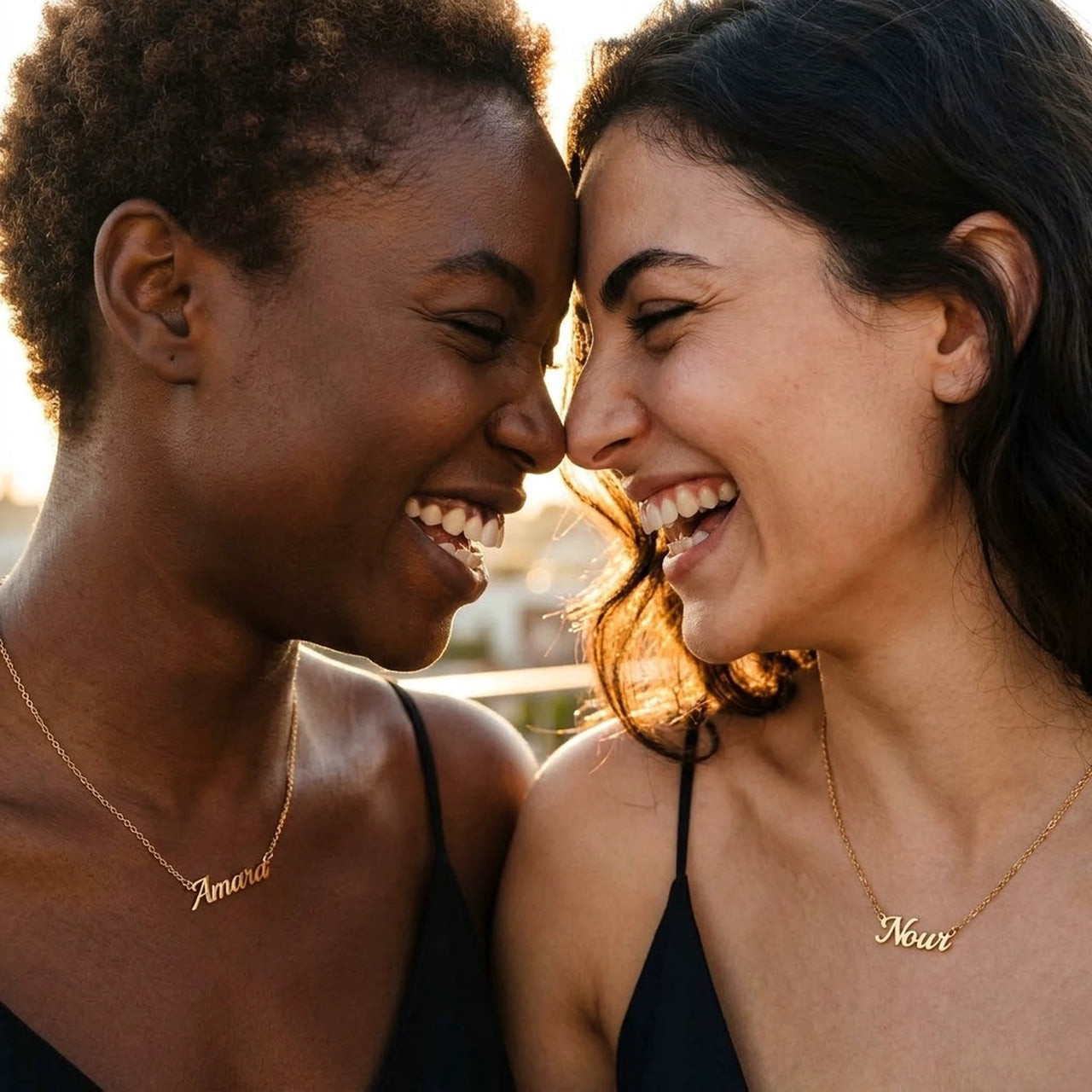 Two women wearing the Minimalist Name Necklace in gold, the names Amara and Nour | SKU: minimalistnn-gold