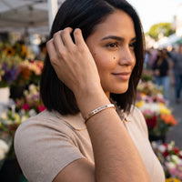 Thumbnail for Woman gently touching her 2020 Survivor bracelet in rose gold | SKU: 2020s-rg