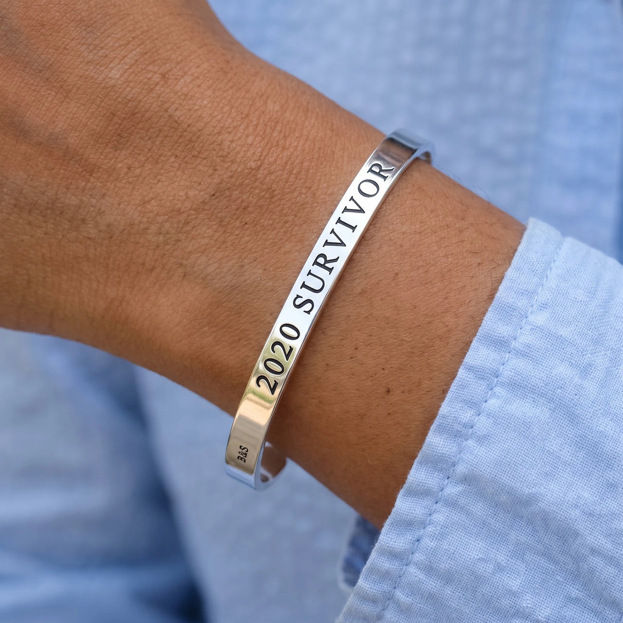 Close-up of the 2020 Survivor bracelet in silver worn | SKU: 2020s-wg