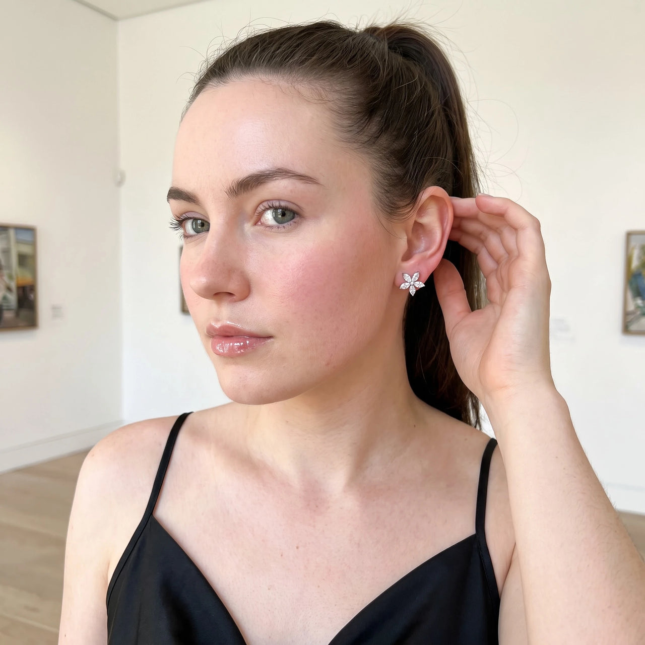 Woman gently touching her Austrian Crystals Flowers Earrings in silver | SKU: 419620-silver