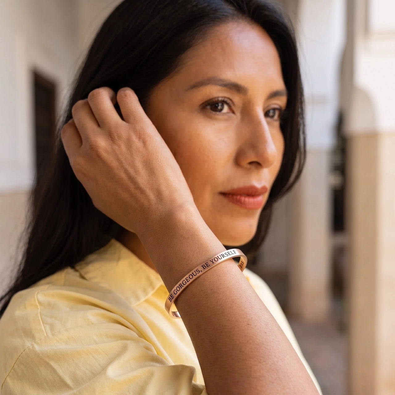Woman gently touching her Be Gorgeous, Be Yourself bracelet in rose gold | SKU: bgby-rg