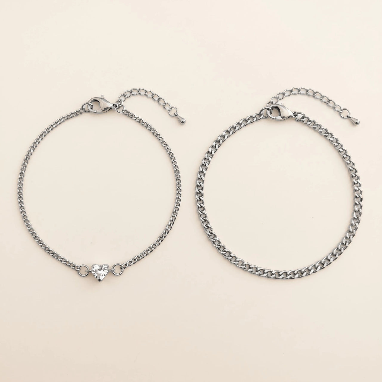 Heart Bond Matching Bracelet Set in Silver — his and hers bracelets side by side: fine curb chain with a tiny heart crystal for her, slim curb chain for him