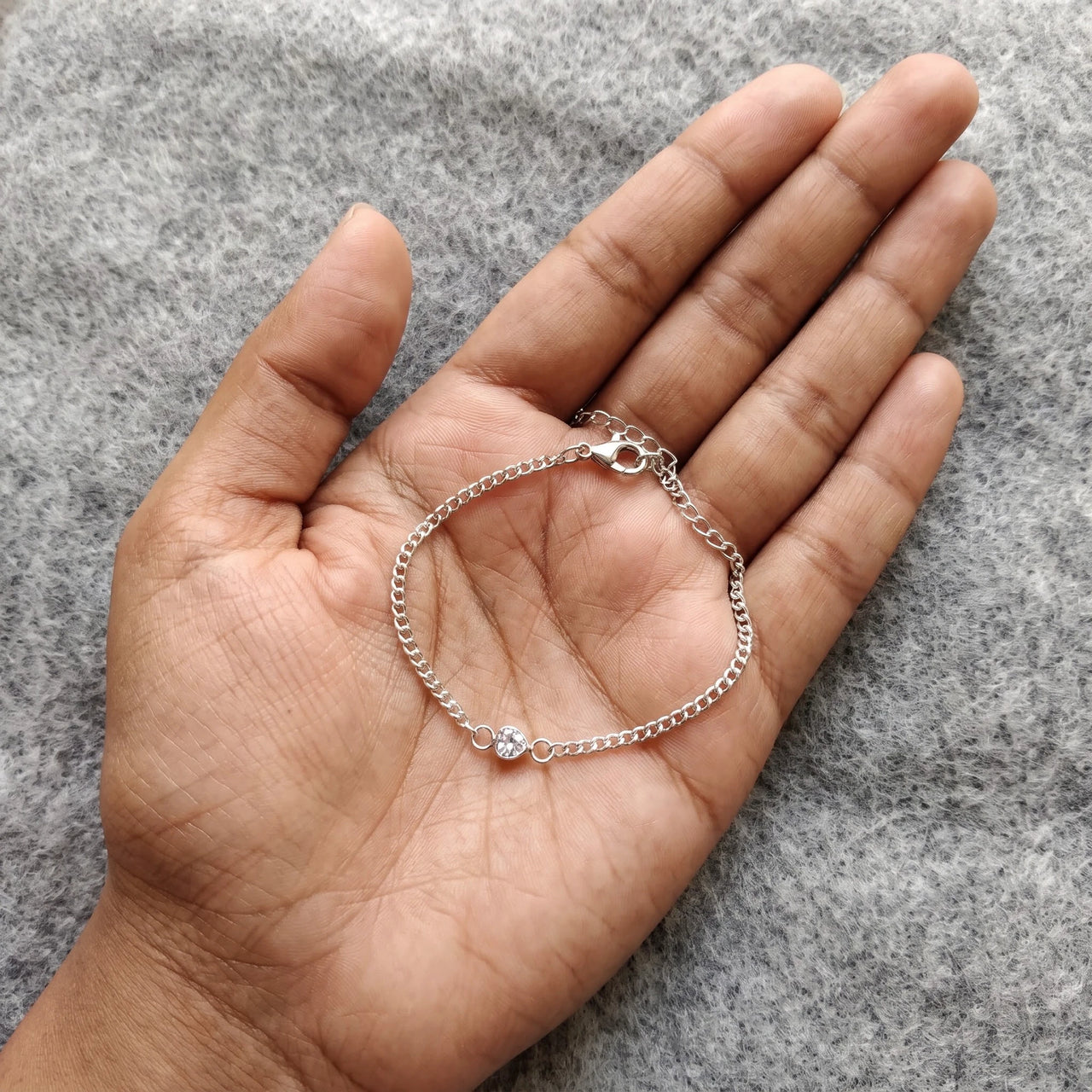 Heart Bond Matching Bracelet Set in Silver — her bracelet resting in an open palm