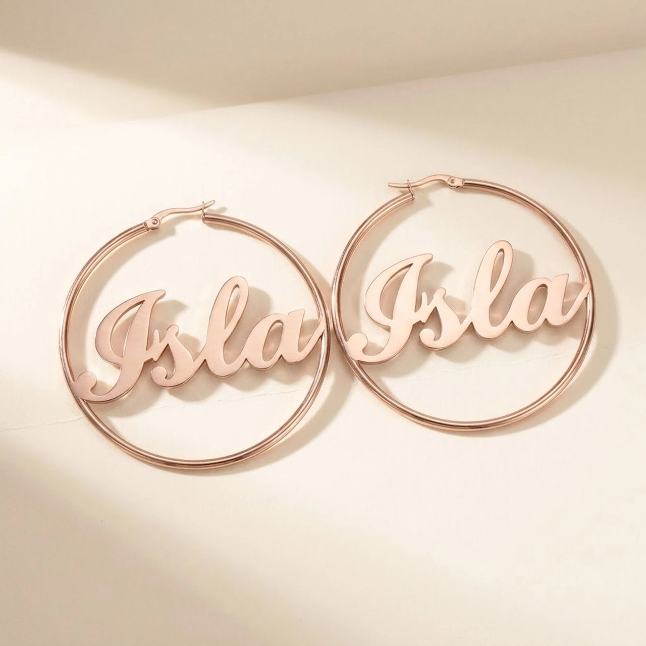 Custom Name Hoop Earrings in Rose Gold, studio packshot of the pair on a plain background | SKU: name-hoop-rose-gold-30-mm