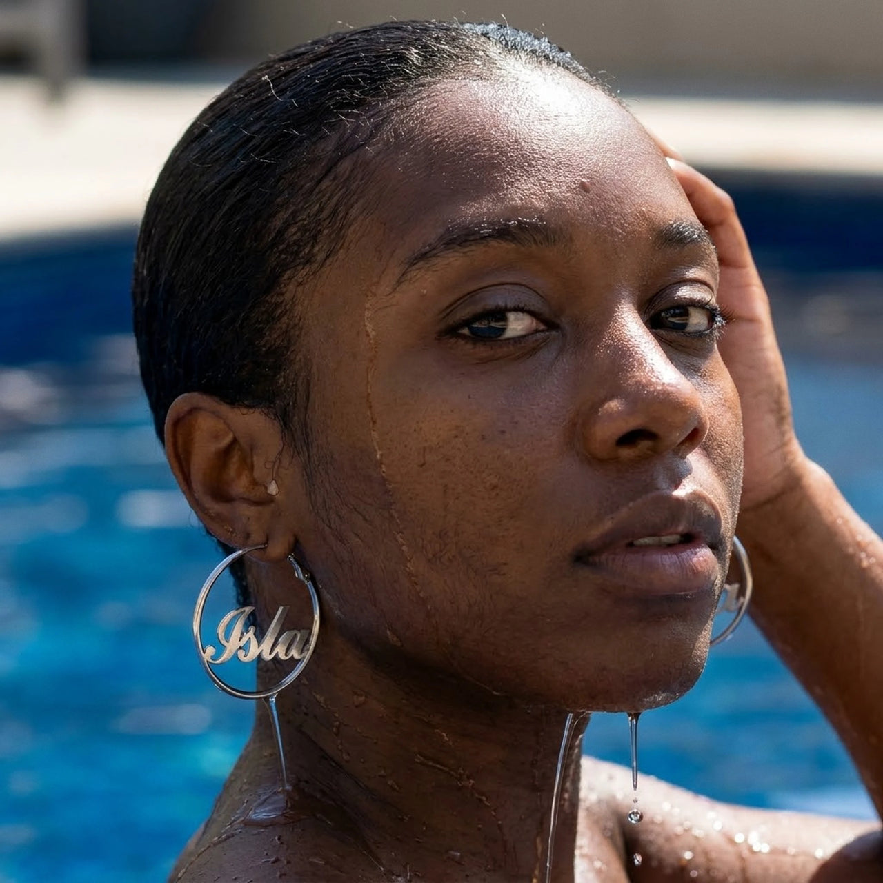 Custom Name Hoop Earrings in Silver worn in a swimming pool, waterproof 304L stainless steel | SKU: name-hoop-silver-30-mm