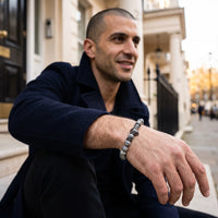 Thumbnail for Black Lion & Grey Stones Bracelet – worn by a man sitting | Brother & Sisters | SKU: 20866222-gun-black-XS-14-15, 20866222-gun-black-S-16-17, 20866222-gun-black-M-18-19, 20866222-gun-black-L-20-21, 20866222-gun-black-XL-22-23