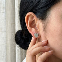 Thumbnail for Heart Initial Stud Earrings in Silver held between the fingertips, scale reference | SKU: heart-initial-silver-a