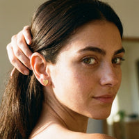 Thumbnail for Heart Initial Stud Earrings in Gold worn on the ear, close-up on a model | SKU: heart-initial-gold-a