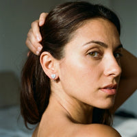 Thumbnail for Heart Initial Stud Earrings in Silver worn on the ear, close-up on a model | SKU: heart-initial-silver-a
