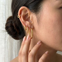 Thumbnail for Huggie Hoop Earrings Set of 4 Pairs in Gold held between the fingertips, scale reference | SKU: huggie-set-gold