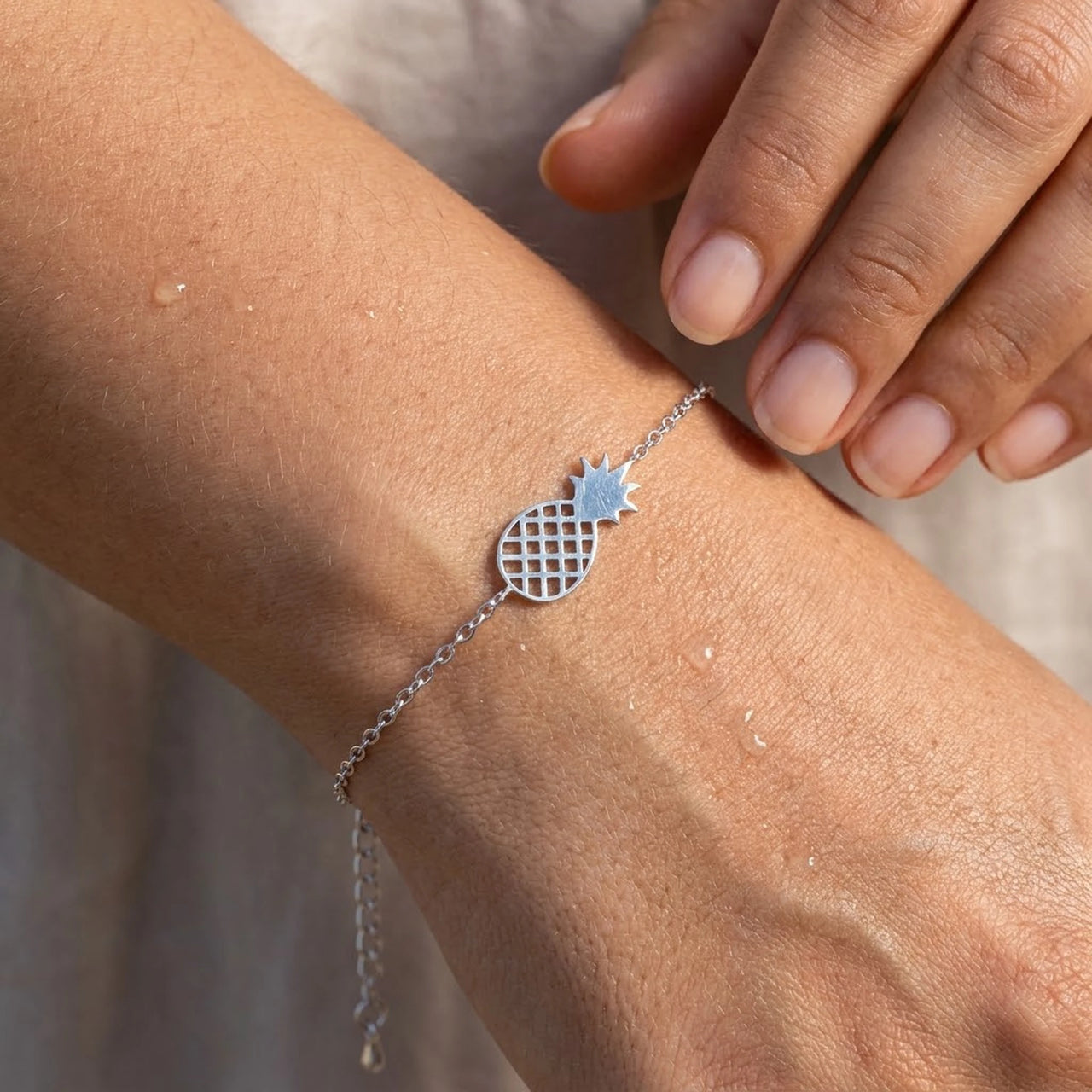 Close-up of the silver charm bracelet worn on the skin | SKU: 9178613-white-gold