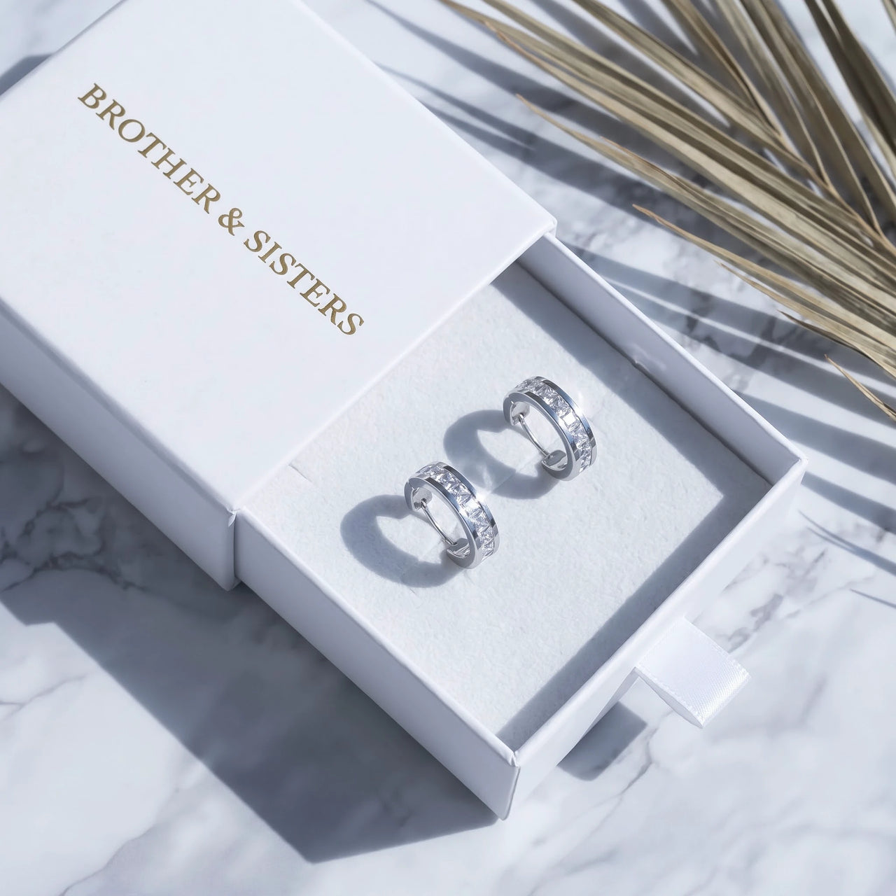 Silver huggie hoop earrings in the Brother & Sisters gift box | SKU: 22023999-rhodium
