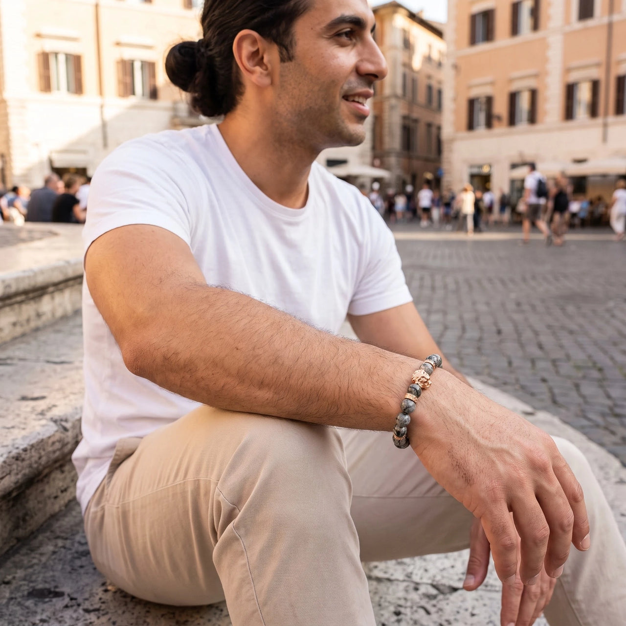 Rose Gold Lion & Grey Stones Bracelet – worn by a man sitting | Brother & Sisters | SKU: 20866222-rose-gold-XS-14-15, 20866222-rose-gold-S-16-17, 20866222-rose-gold-M-18-19, 20866222-rose-gold-L-20-21, 20866222-rose-gold-XL-22-23