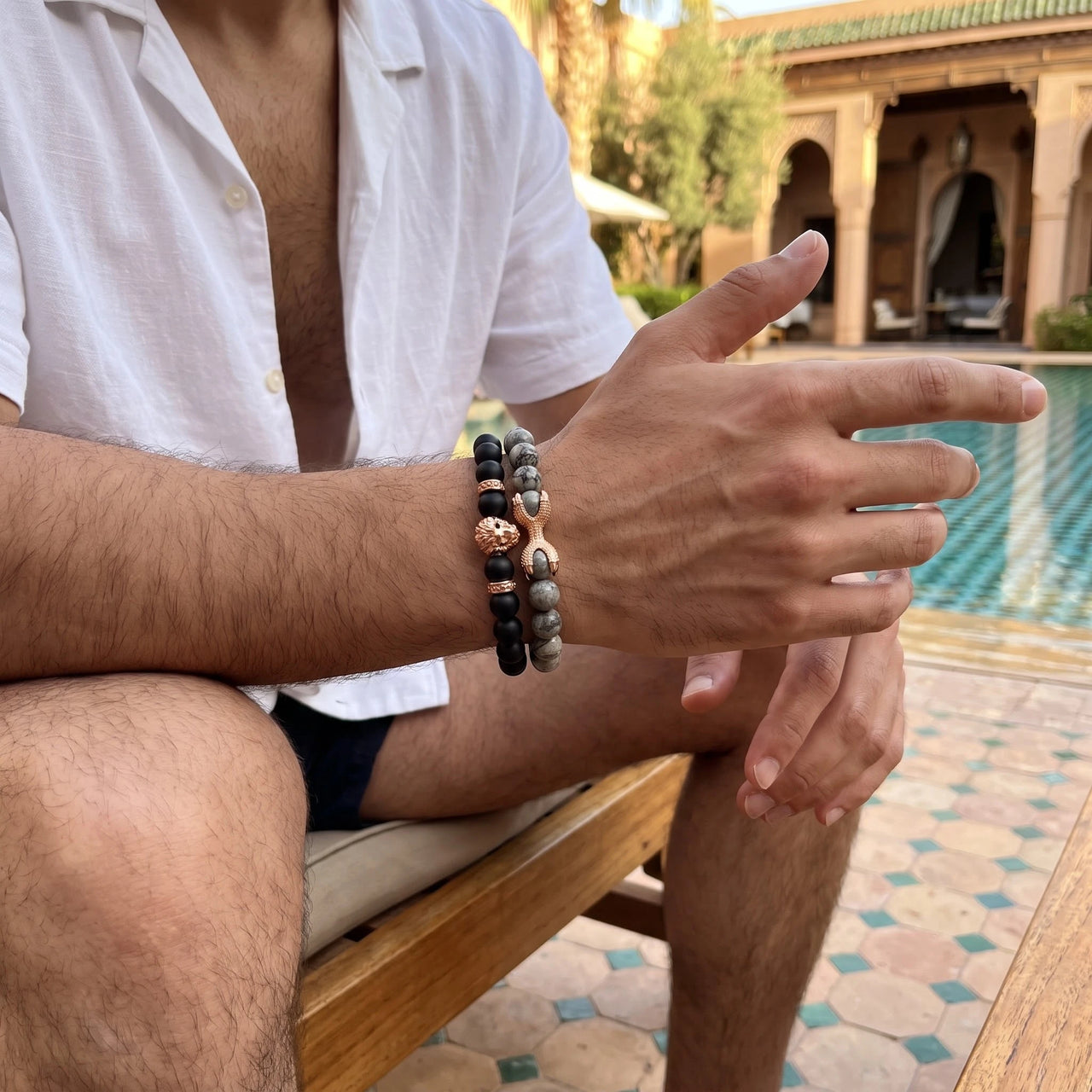 Rose Gold Lion with Black & Grey Stones Set – worn by a man sitting | Brother & Sisters | SKU: 21369621-rose-gold-XS-14-15, 21369621-rose-gold-S-16-17, 21369621-rose-gold-M-18-19, 21369621-rose-gold-L-20-21, 21369621-rose-gold-XL-22-23