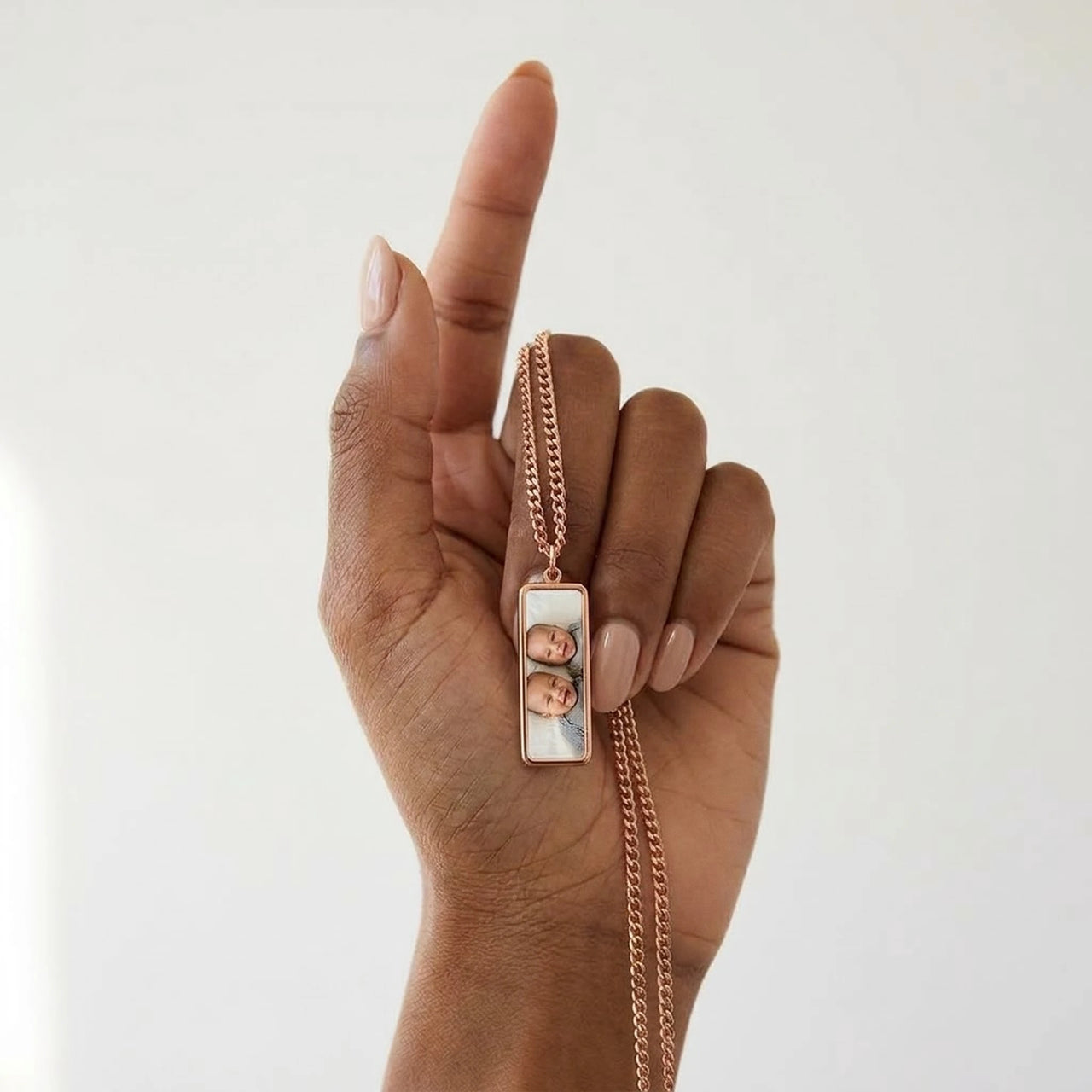 Rose gold bar pendant next to her finger, real small size, twins' photo inside | SKU: TPH-BARN-ROSEGOLD