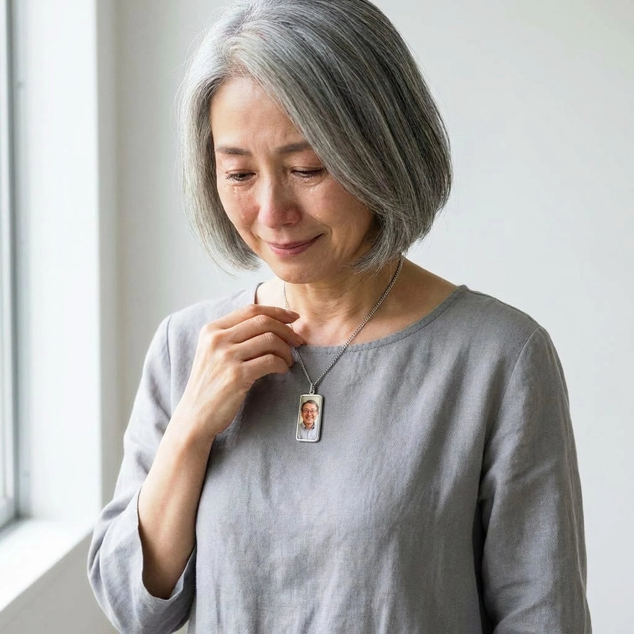 Woman moved as she looks at her late husband's photo in the silver bar necklace | SKU: TPH-BARN-SILVER
