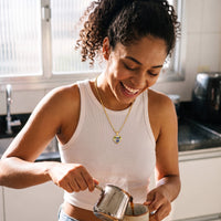 Thumbnail for Woman laughing in her kitchen, wearing the gold secret heart photo necklace | SKU: TPH-CHTN-GOLD-SMALL