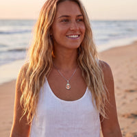 Thumbnail for Woman on a beach at sunset wearing the silver secret drop photo necklace | SKU: TPH-DRPN-SILVER