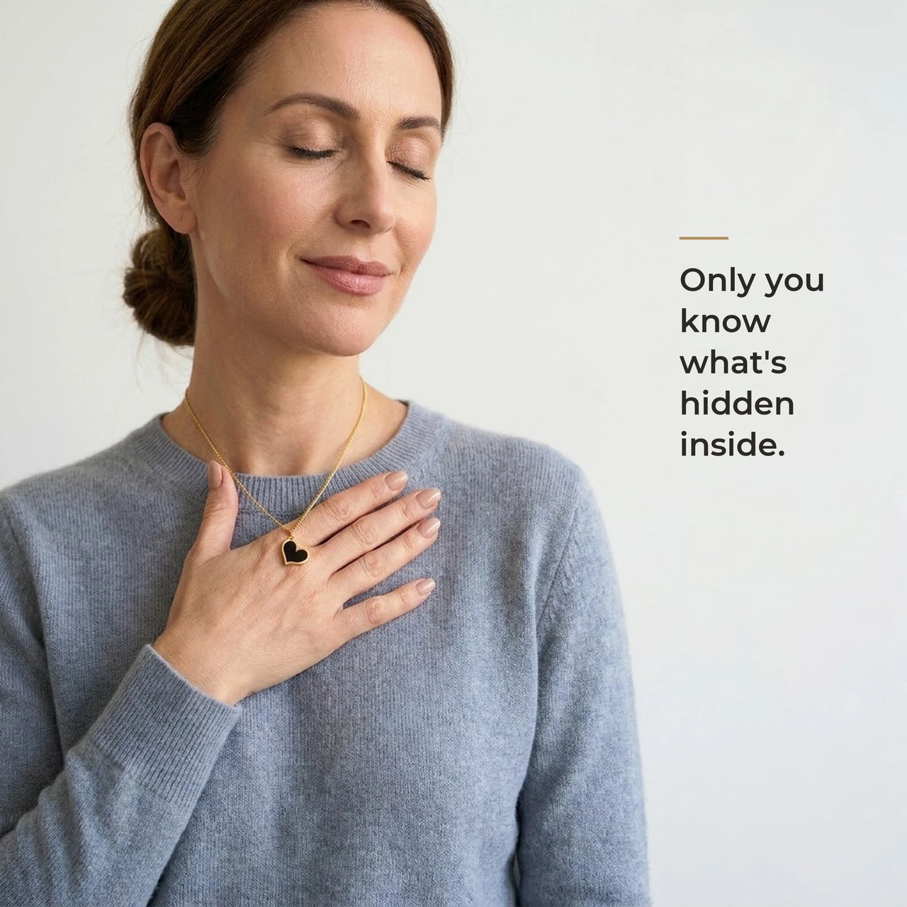 Woman holding the black heart pendant against her chest, only she knows the photo inside | SKU: TPH-HRTN-GOLD