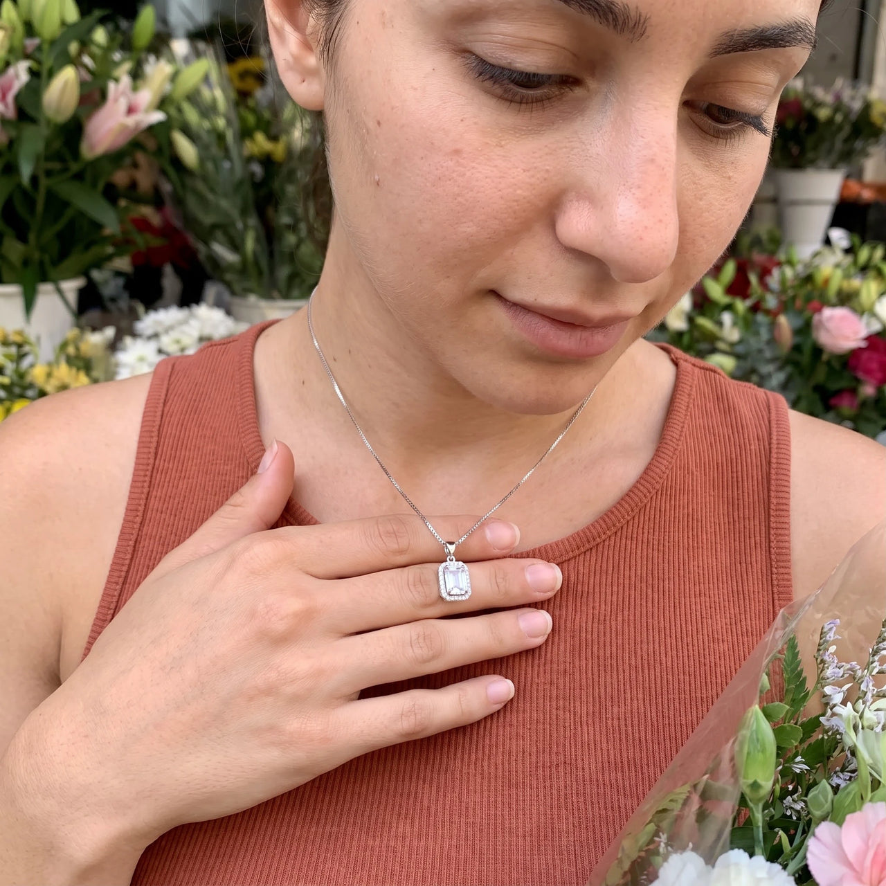 Woman gently touching her silver necklace | SKU: 22559056