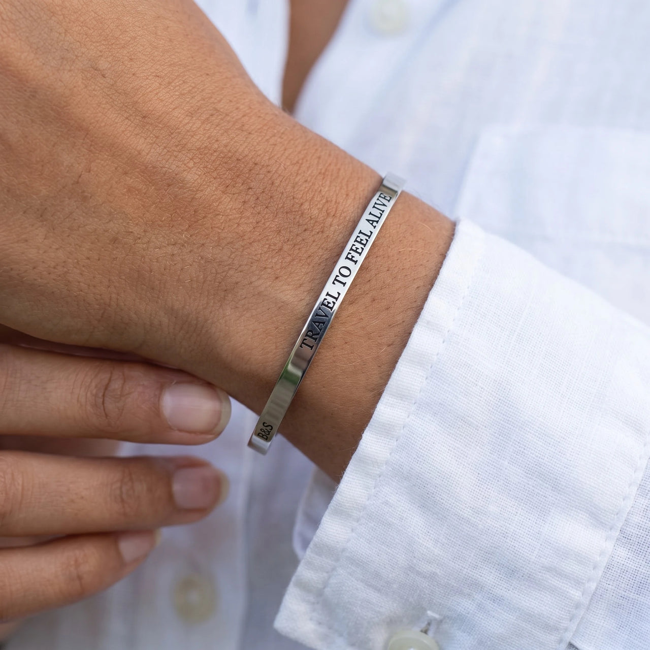 Close-up of the Travel To Feel Alive bracelet in silver worn | SKU: ttfa-wg