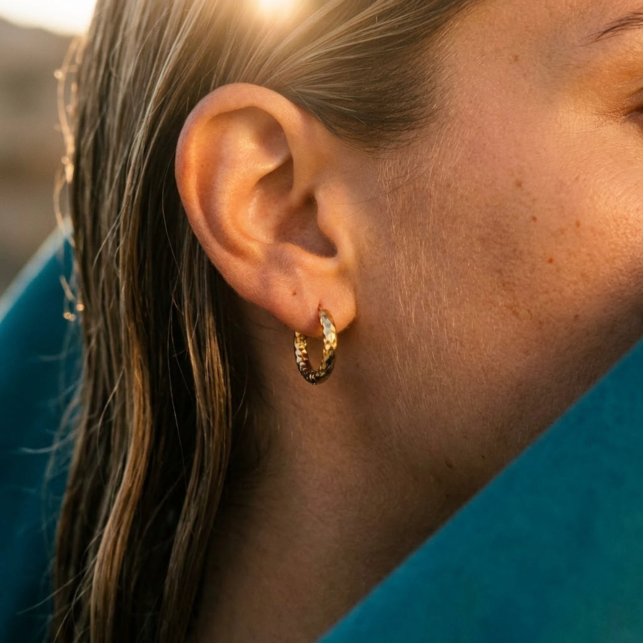 Twisted Rope Huggie Hoops in Gold, close-up on the earlobe | SKU: 41012-gold